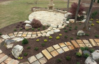 garden flagstone paver leading to a flagstone patio with an outdoor stone fireplace