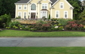 a manicured lawn and well-cared plants in front of a house