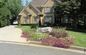 a house with a manicured lawn and well-cared plants
