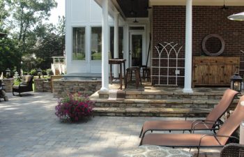 a house with a flagstone porch and paver patio