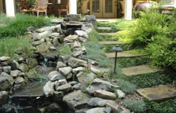 a flagstone paver next to the garden stream with designed hardscape