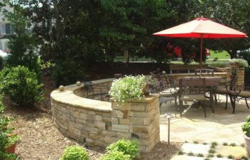 a flagstone patio with retaining walls in the backyard