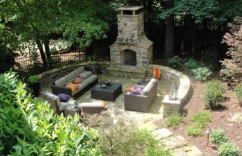 a backyard flagstone patio with an outdoor stone fireplace